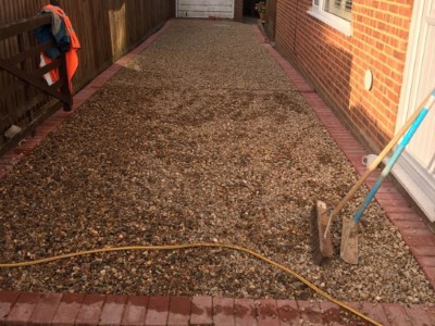 Gravel driveway with a red brick border