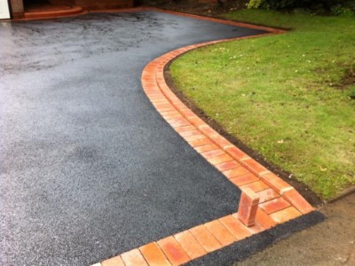 Curved boundary line with brick on edge around garden